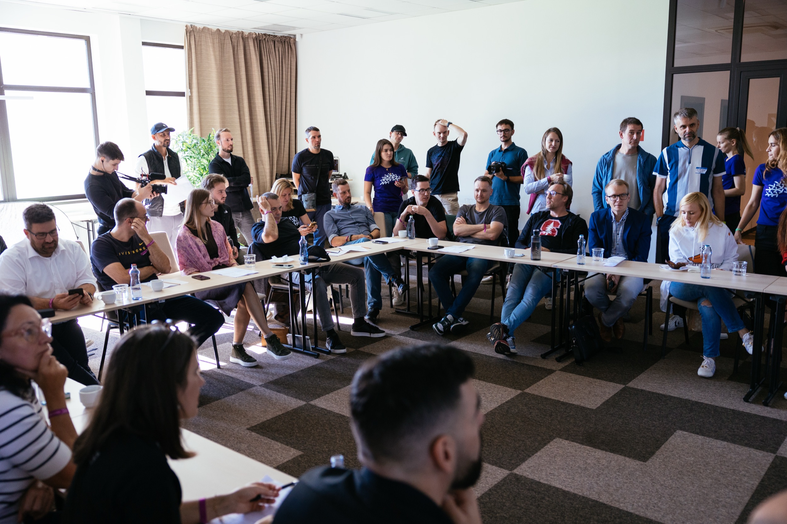 Mentoring na Bootcampe – startupisti a mentori za stolmi v tvare U