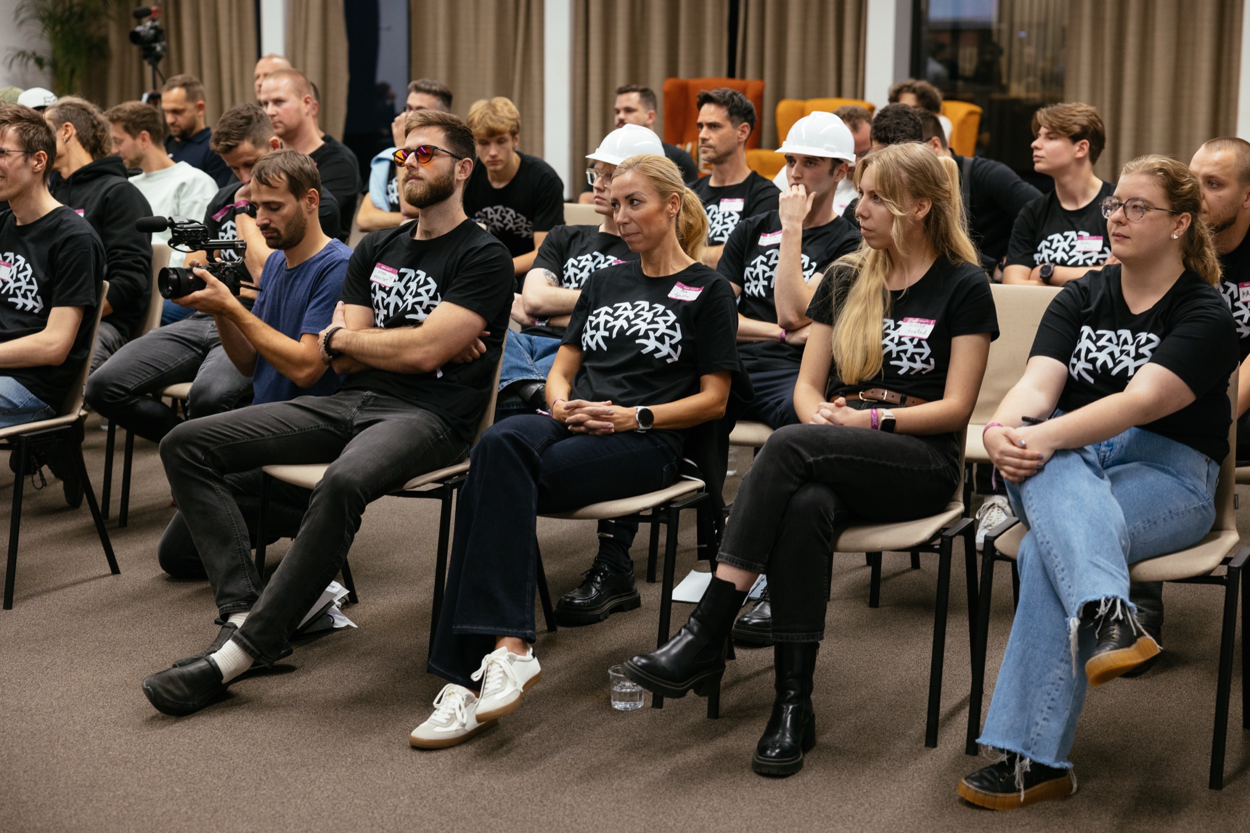 Účastníci Bootcampu v tričkách SASK počúvajú prednášku